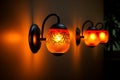 Artistic illumination wallmounted lamp casts a warm yelloworange glow Royalty Free Stock Photo