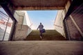 Artistic image composition of female in sportswear with a bag on her shoulder, going up the stairs. copy space