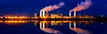 Industrial landscape with smoking chimneys and reflection in water at night Royalty Free Stock Photo