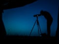 Artistic long exposure photo of a photographer in action. Multiple silhouettes and a camera un tripod. Royalty Free Stock Photo