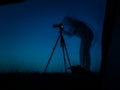 Artistic long exposure photo of a photographer in action. Multiple silhouettes and a camera un tripod. Royalty Free Stock Photo