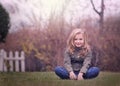 Artistic outdoor portrait of a cute blond girl holding on to a fence Royalty Free Stock Photo