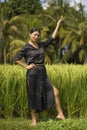 Artistic portrait of young attractive and happy Asian woman outdoors at green rice field landscape dancing and doing yoga Royalty Free Stock Photo