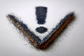 Artistic representation of an exclamation mark using charcoal powder on textured paper highlighting creativity and Royalty Free Stock Photo