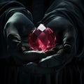 Mysterious person holding a glowing red gem in the dark. thriller style image with a concept of discovery or secrets