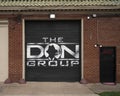 Artistic sign mural for The Don Group on a roll down garage door at their office in Deep Ellum, Texas.