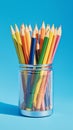 Artistic stationery display Colorful pencils in metal jar, blue backdrop Royalty Free Stock Photo