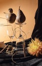 Artistic still life with pears, shell, wine glasses and medlar in combination with orange flower