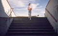 Artistic symmetrical image of a caucasian female running down the stairs in sportswear