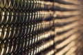 Artistic view of black chain link fence in evening sunlight