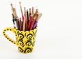 An artistic yellow cup with art supplies Royalty Free Stock Photo