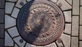 An artistically designed circular manhole cover with a geometric pattern. Royalty Free Stock Photo