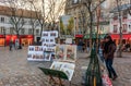 Artists awaiting customers amongst easels and artwork set up in Place du Tertre in Montmartre Paris, France