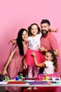 Artists family hugs on pink background. Creativity and family concept Royalty Free Stock Photo