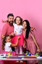 Artists family hugs on pink background. Creativity and family concept Royalty Free Stock Photo