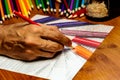 An Artists hand at work using colored pencils to draw colored pe Royalty Free Stock Photo