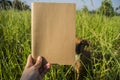 Hand hold on the brown notebook with natural light in garden outdoor at Chiang Ma,Thailand.