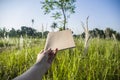 Hand hold on the brown notebook with natural light in garden outdoor at Chiang Ma,Thailand.