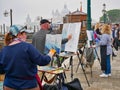 Artists painting in St Mark`s Square in Venice, Italy, on a misty, overcast day