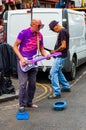 Artists performing outdoors on the street. Two strange funny looking men performing on Portobello Road in London