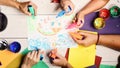 Artists wooden table with paints and colored paper. Art and idea concept. Hands hold colorful markers Royalty Free Stock Photo