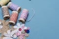 Arts and crafts background image of colourful twine with buttons and safety pins