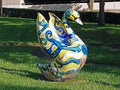 Artsy decorative ceramic goose resting in a green grass lawn.