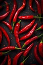 Hot chili peppers depicted in contrast against a dark background. The juicy, red peppers create a visual effect.