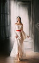 Woman dark hair bare shoulders long white vintage medieval luxurious dress. Royalty Free Stock Photo