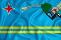 ARUBA flag Close-up shot on waving background texture with Fuel pump nozzle in hand. The concept of design solutions. 3d rendering