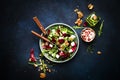 Arugula, Beet and cheese salad with fresh radicchio and walnuts on plate with fork, dressing and spices on blue kitchen table