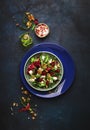 Arugula, Beet and cheese salad with fresh radicchio and walnuts on plate with fork, dressing and spices on blue kitchen table