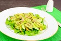 Arugula salad, kiwi and cucumber on white plate