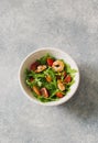 Arugula, tomatoes and shrimps salad on blue stone background Royalty Free Stock Photo