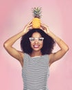 As cool as a pineapple. Studio shot of a beautiful young woman posing with a pineapple on her head. Royalty Free Stock Photo