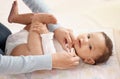 As cute as a button and clean as a whistle. a woman changing her adorable baby girls diaper at home.