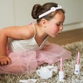 As girly as girlhood gets. an adorable little girl having a make believe party at home.