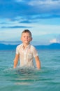 Close-up portrait of a handsome boy in wet slim fit shirt jumps and flutters over the water, a lot of splashes and