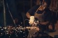 .As in life, the successful forge on. a young man using an angle grinder while working at a foundry.