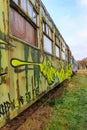 As, Limburg, Belgium. December 17, 2023. Side perspective of very old green passenger car painted with graffiti Royalty Free Stock Photo