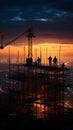 As night falls, the construction site silhouette reveals crane and laborers