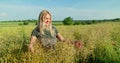 Harvest vigilance: portrait of a woman inspecting rapeseed crop in July