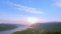 Sunrise golden hour aerial hovering above forest, tilt down revealing morning sun reflecting off the Columbia River & Vista House