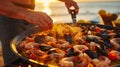 As the sun sets over the ocean the host prepares a mouthwatering seafood paella using freshly caught shrimp clams and Royalty Free Stock Photo
