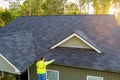 As worker is cleaning clogged roof gutter drain from dirt, debris, fallen leaves