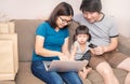 Asain parents and their daughter are doing shopping online using laptop Royalty Free Stock Photo