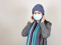 Asain woman wearing medical face mask and knitted hat and winter coat indoor.Covid-19 prevention, new normal, winter portrait