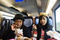 Asain women mother and daughter eating snack and listen music on mobile phone on train