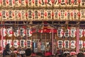 Crowd ringing the bells of Ootori shrine decorated with luminous handwritten paper lanterns.