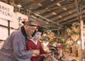 Japanese woman in kimono holding an auspicious rake with a man in happi jacket at Tori-no-Ichi Fair.